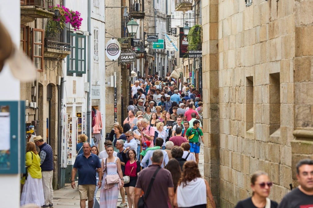 Pilgrims and tourists walk in the old centre of Santiago de Compostela, a Spanish city struggling with overtourism. Photo: AP