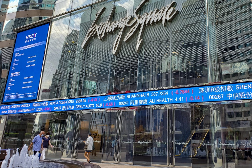 People walk past stock information signs in Exchange Square in Central on August 18, 2022. Photo: Matthew Miller