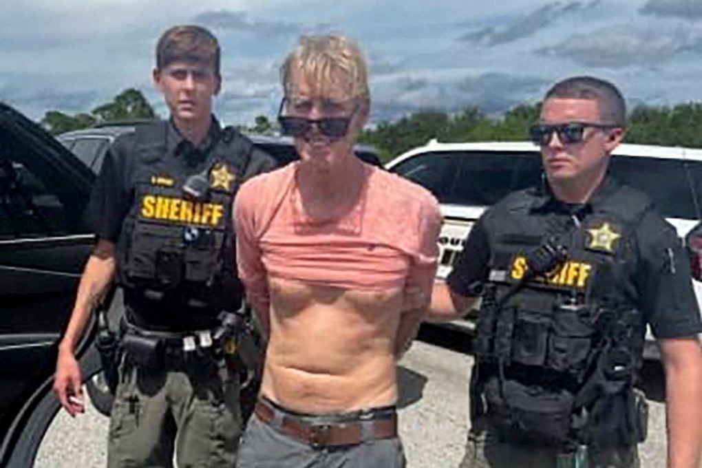 Ryan Routh stands handcuffed between two Martin County Sheriff’s office deputies after his arrest near Palm City, Florida, in September 2024. Photo: Martin County Sheriff’s Office via Reuters