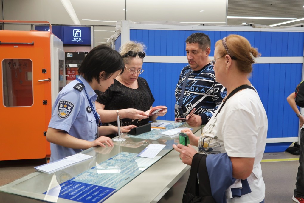 An immigration officer helps Russian travellers to fill in arrival cards in east China’s Shanghai on September 15. Photo: Xinhua