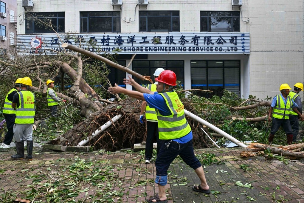 Workers cut and remove a fallen tree following the passage of Super Typhoon Ragasa in Yangjiang, Guangdong province, on Thursday. Photo: AFP