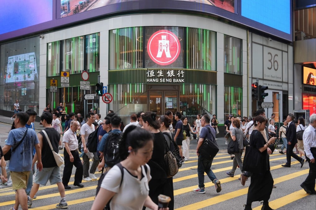 People cross Queens Road in Central in front of a Hang Seng Bank branch on July 30, 2025. Photo: Eugene Lee