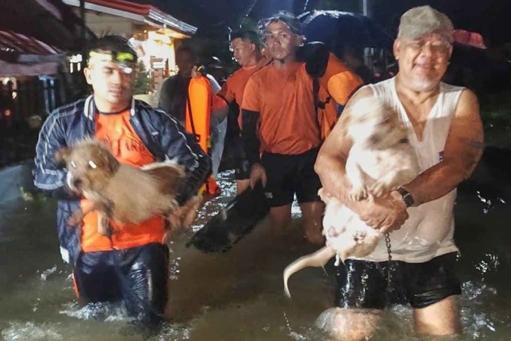 Filipino rescuers help residents and their pets evacuate their flooded homes in Ormoc, Leyte province, Philippines, on Friday. Photo: Philippine Coast Guard/AP