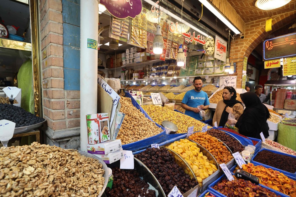 Iranian women speak with a shop owner at the Grand Bazaar in Tehran on Saturday. Iran’s government put overall annual inflation at 34.5 per cent in June. Photo: AFP