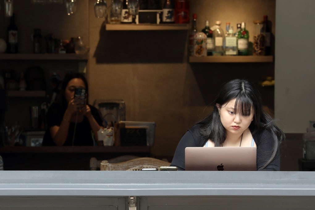 Young women using their laptops and phones in a Hong Kong cafe. Online platforms have been buzzing with discussions about the work culture of Gen Z people. Photo: Sun Yeung