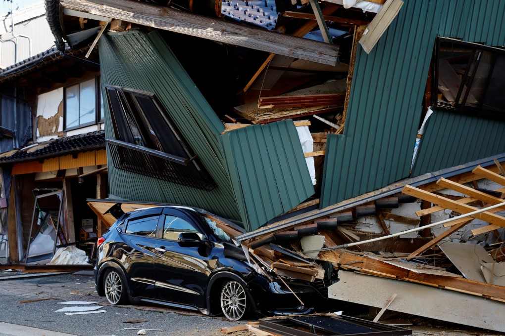 A damaged car stands near a collapsed house, following an earthquake, in Nanao, Japan, on January 2, last year. Photo: Reuters