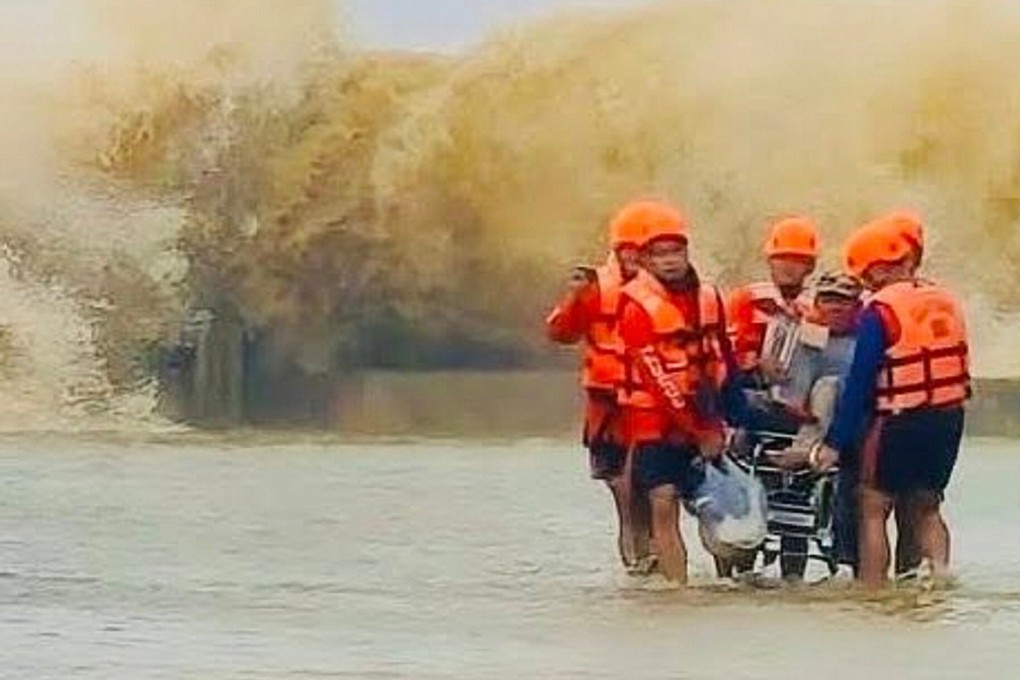 Rescuers evacuate a resident on a wheelchair as waves from Severe Tropical Storm Bualoi batter the sea walls on Friday. Photo: Philippine Coast Guard/AP