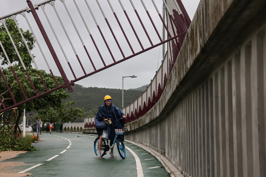A cyclist looks at a broken fence on a cycle path damaged by Super Typhoon Ragasa in Hong Kong on September 24. Photo: Reuters