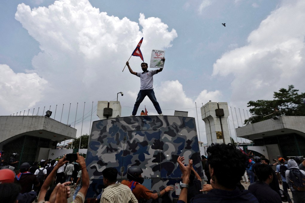 A young protester waves the Nepalese flag as he stands atop a vehicle near the entrance of parliament in Kathmandu on September 8. Photo: Reuters