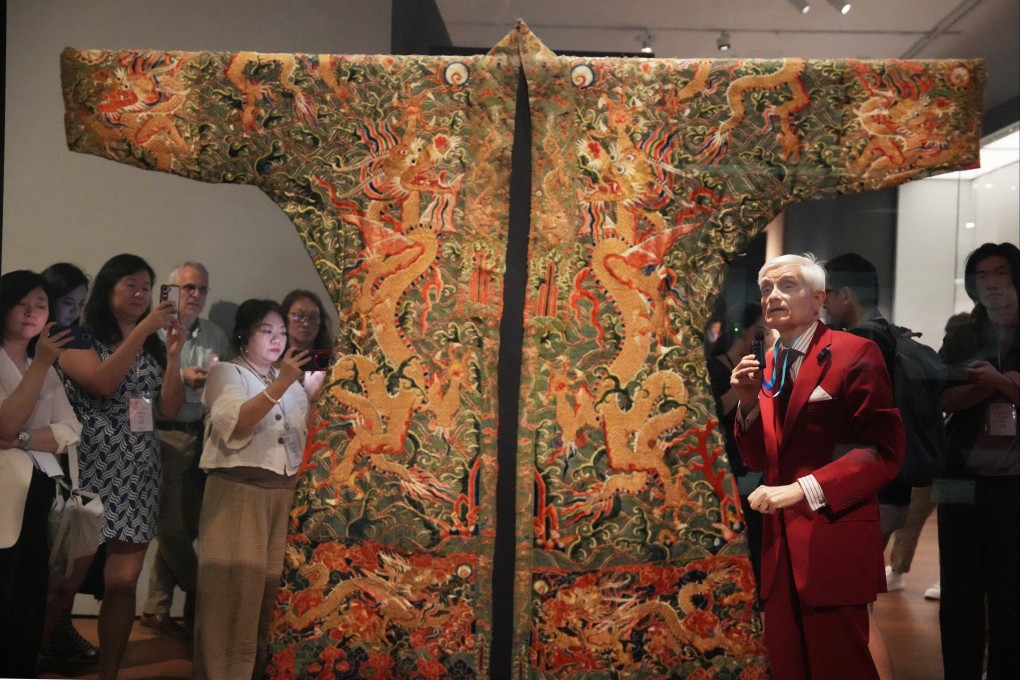 Chris Hall (in red) shares about one of his silk collections on display. Photo: May Tse