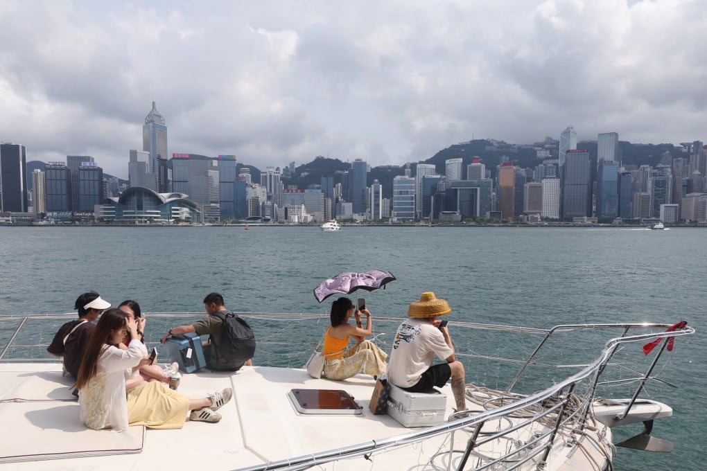 Tourists take in the view of Victoria Harbour from a yacht. Photo: Edmond So