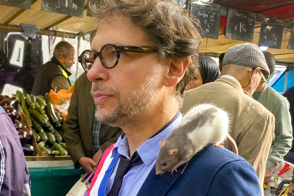 Plume sits on the shoulder of Gregory Moreau as the deputy mayor of Paris’ 11th district strolls through a market in the Belleville neighbourhood on September 16. Photo: AFP