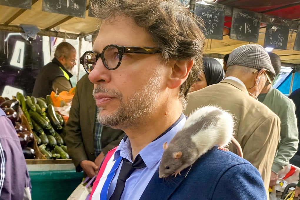 Plume sits on the shoulder of Gregory Moreau as the deputy mayor of Paris’ 11th district strolls through a market in the Belleville neighbourhood on September 16. Photo: AFP