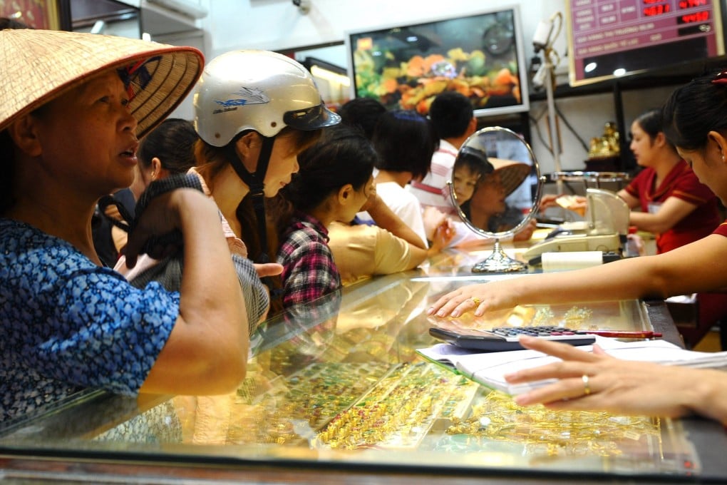 Customers buy and sell gold at a local gold shop in Hanoi. Photo: AFP