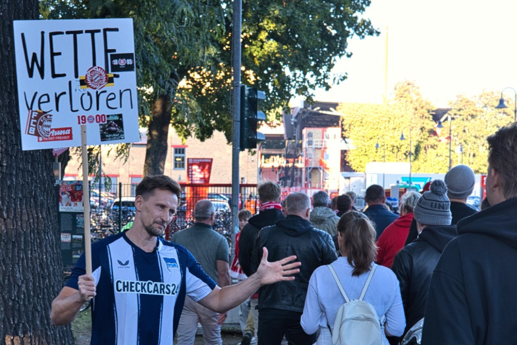 Thomas Melchior, who used to be addicted to sports gambling, holding up a sign saying “lost a bet” at a German football match in Köpenick, Berlin on Sunday. Photo: AP