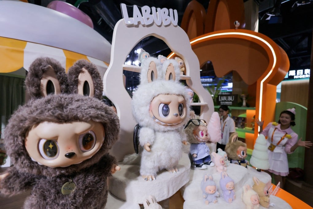 An employee stands next to Labubu toys at Pop Mart’s booth at the China International Fair for Trade in Services in Beijing, in September 2025. Pop Mart is planning to invest in “developing content, theme parks, store displays” for Labubu. Photo: Reuters