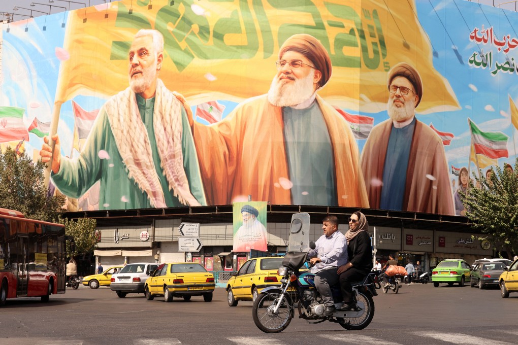 Iranians ride a motorcycle in front of a billboard depicting slain Lebanese Hezbollah leaders in Tehran on September 28. Iran has condemned as “unjustifiable” the reinstatement of United Nations sanctions over its nuclear programme, after the collapse of talks with Western powers and Israeli and US strikes on its nuclear sites. Photo: AFP