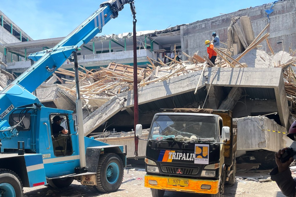 A crane is brought in to clear the rubble at the site where a building under construction at an Islamic boarding school. Photo: AP