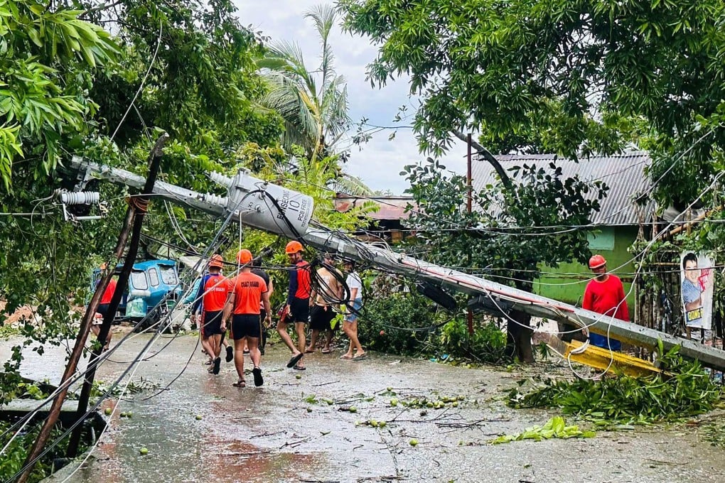 Philippine Coast Guard personnel walk past a fallen electric post toppled at the height of Severe Tropical Storm Bualoi, during clearing operations in Romblon town, central Philippines on September 26. Photo: Philippine Coast Guard / AFP