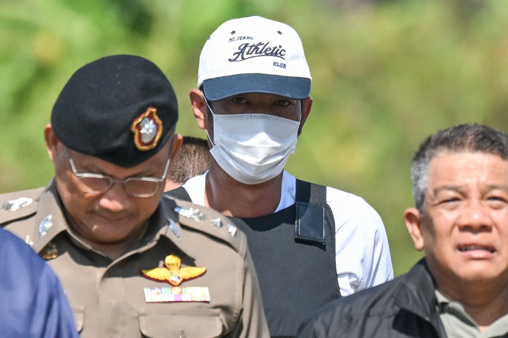 Thai police officers escort Ekkalak Pheanoi (centre), accused of killing of Cambodian politician Lim Kimya, after he is deported from Cambodia on January 11. Photo: AP