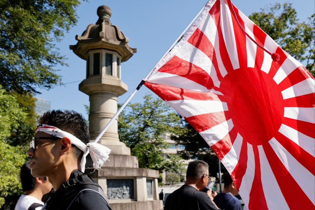 A person displays a Rising Sun flag at the Yasukuni shrine in Tokyo on the 80th anniversary of Japan’s surrender in WWII on August 15. Photo: Reuters
