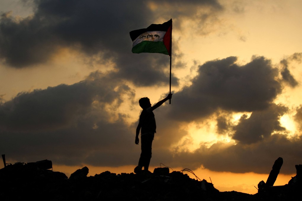 A displaced Palestinian child waves the Palestinian national flag at the Bureij camp for refugees in the central Gaza Strip on September 22. Photo: AFP