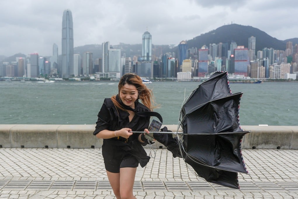 A woman contends with strong winds at the West Kowloon Cultural District on Saturday afternoon. Photo: Eugene Lee