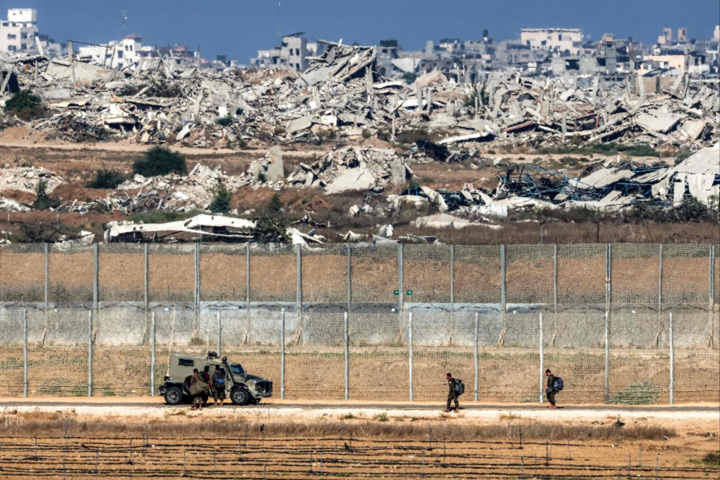 Israeli army soldiers walk towards an armoured vehicle in southern Israel along a border fence with the Gaza Strip last month. Photo: AFP