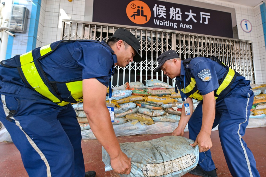Port staff lay sandbags outside a waiting area in Haikou, capital of Hainan province, on Sunday. Photo: Xinhua