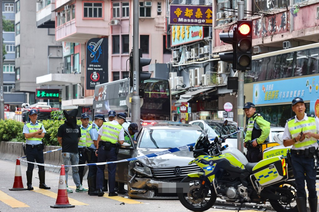Police officers inspect a crashed vehicle after taking the suspect (second from left) into custody. Photo: Karma Lo