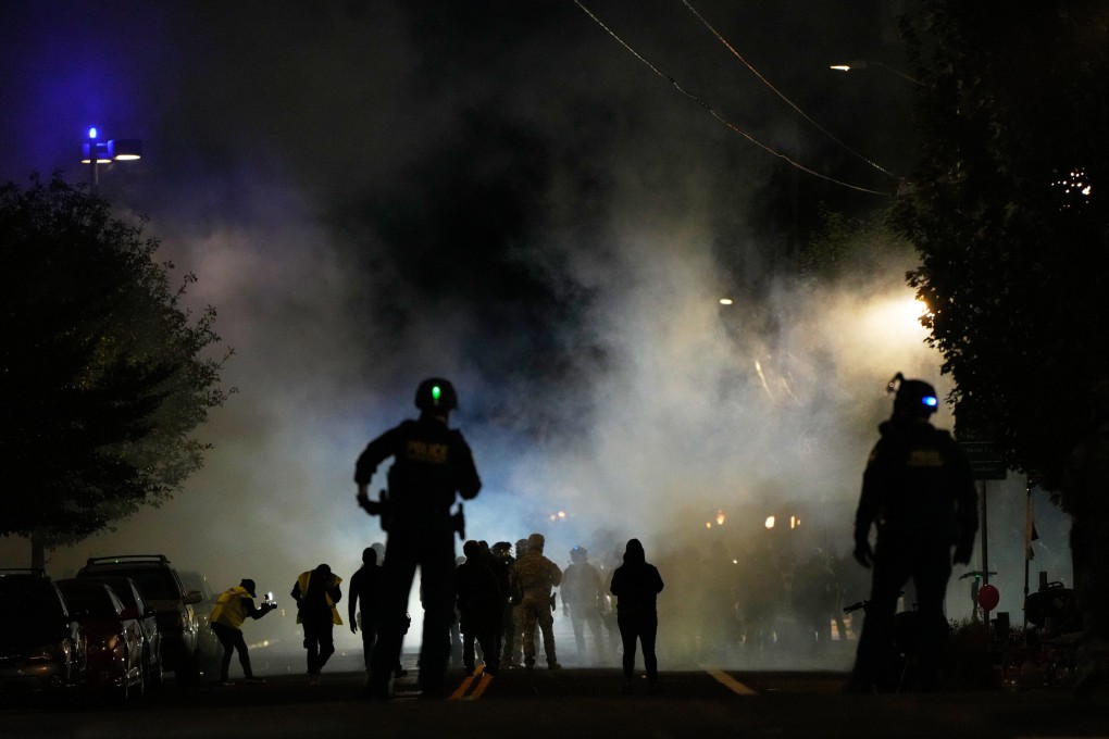 Law enforcement officers after deploying tear smoke outside a US Immigration and Customs Enforcement facility during a protest on Saturday in Portland, Oregon. Photo: AP
