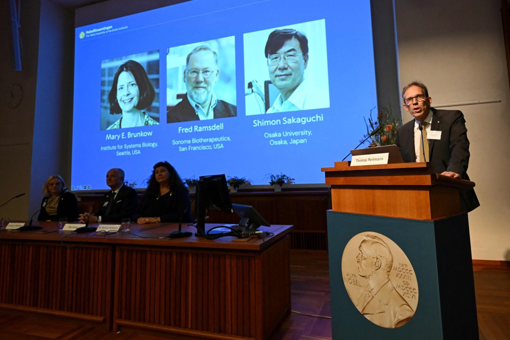 Nobel Committee Secretary General Thomas Perlmann (right) addresses journalists in front of a screen displaying the portraits of the winners of the 2025 Nobel Prize in Physiology or Medicine on Monday. Photo: AFP