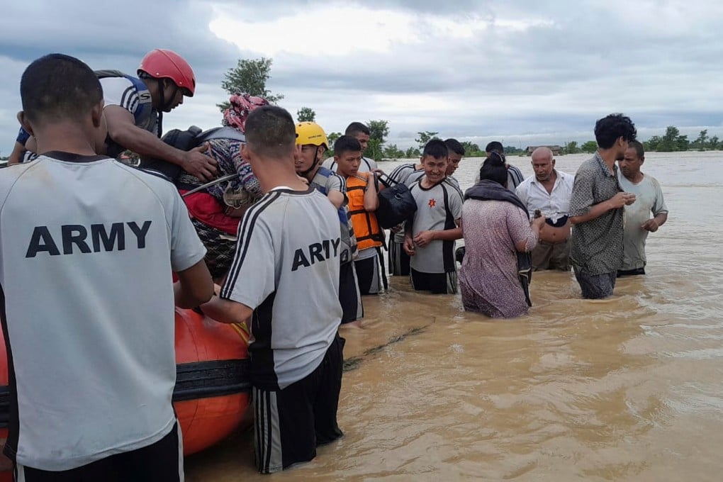 Nepalese army staff help survivors after a flood in Jhapa district in eastern Nepal on Sunday. Photo: Nepal Army/AP