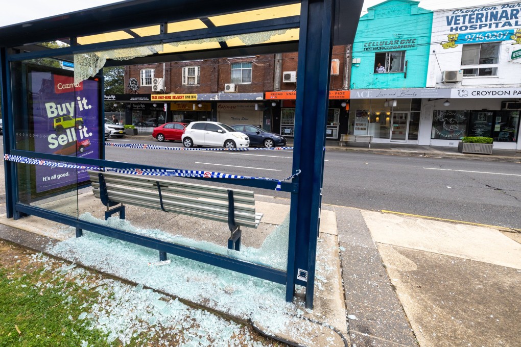 A bus stop with a shattered glass panel is seen at the scene of a shooting in Croydon Park in Sydney on Monday. Photo: EPA