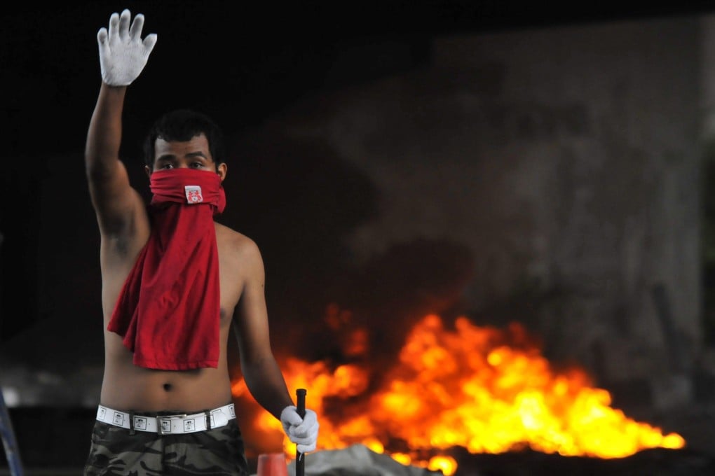 An anti-government protester gestures near Victory Monument in Bangkok, Thailand in May 2010. Photo: EPA