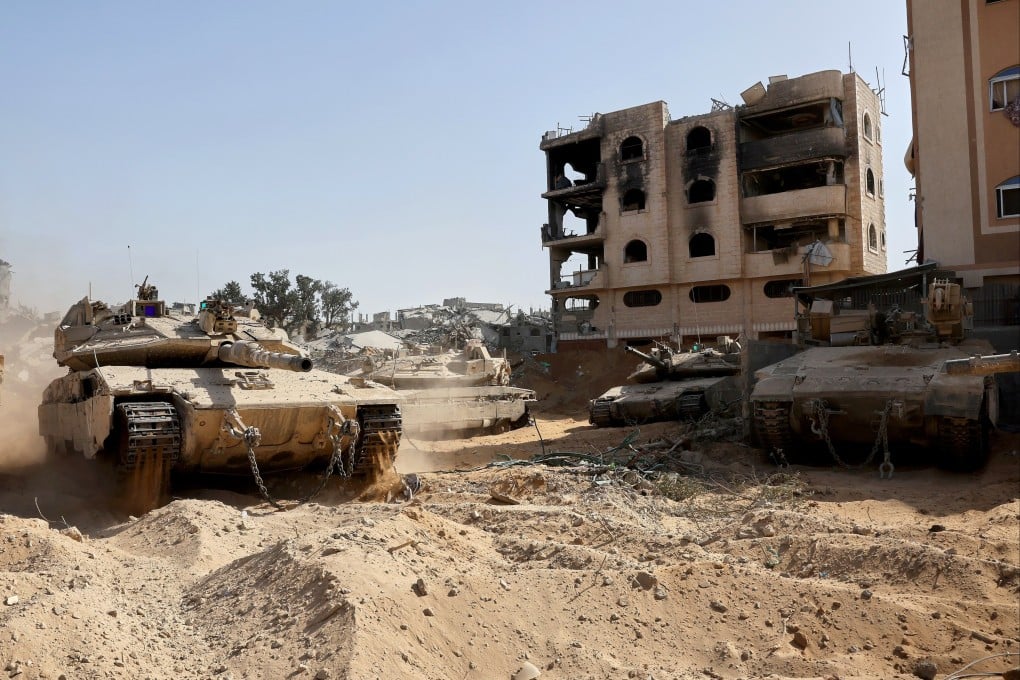 sraeli army tanks and armoured personnel carriers are stationed near war-damaged buildings in Gaza City, on October 3. Photo: AP