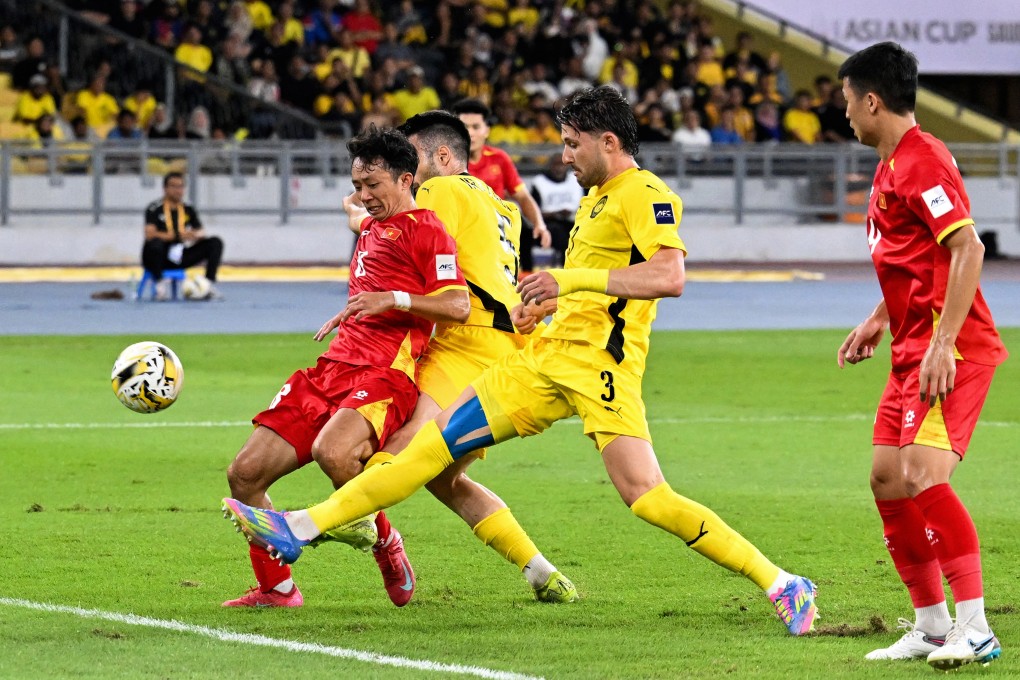 Vietnam’s Chau Ngoc Quang (left) fights for the ball with Malaysia’s players during the Asian Cup qualifier match between Malaysia and Vietnam in Kuala Lumpur on June 10. Photo: AFP