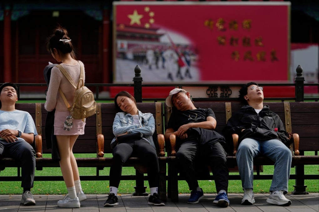 Tourists nap outside barracks for honour guards near the Forbidden City during the National Day holidays in Beijing on October 1. China’s export machine thrives while domestic consumption stalls. Photo: AP