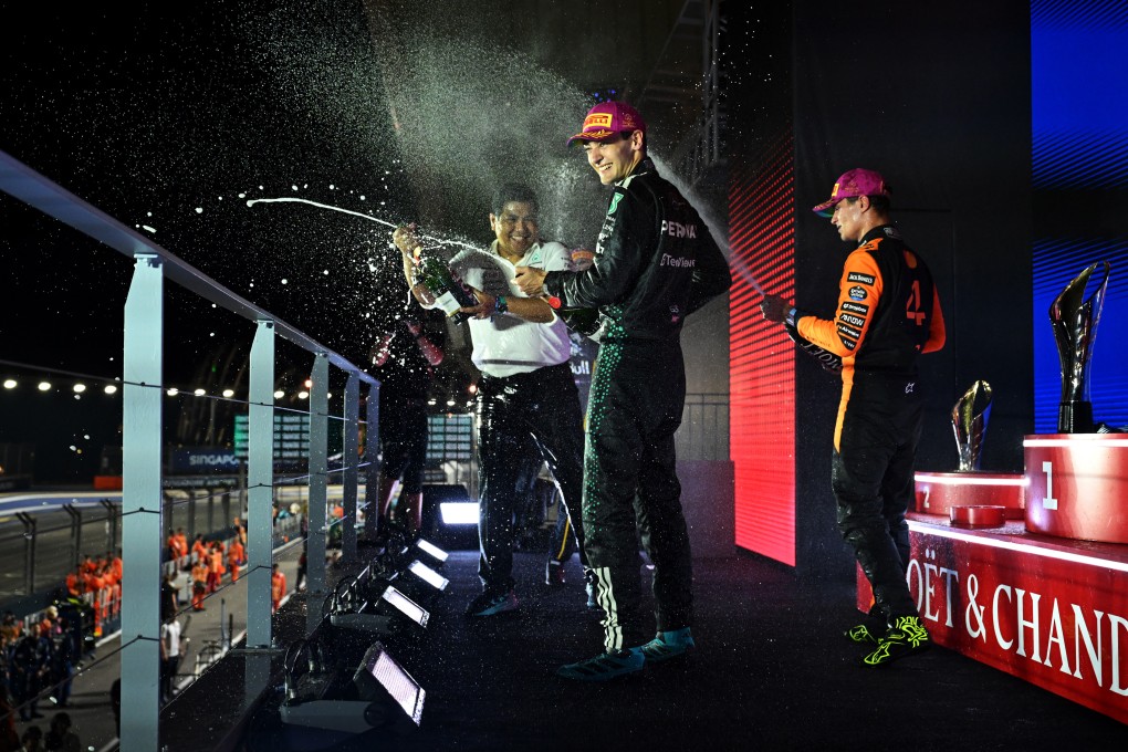 Race winner George Russell (centre) of Mercedes-AMG Petronas Formula One Team, Petronas CEO Tengku Muhammad Taufik Tengku Aziz (left) and third-placed Lando Norris of McLaren celebrate on the podium with champagne during the Singapore Grand Prix on Sunday. Photo: Formula 1 via Getty Images