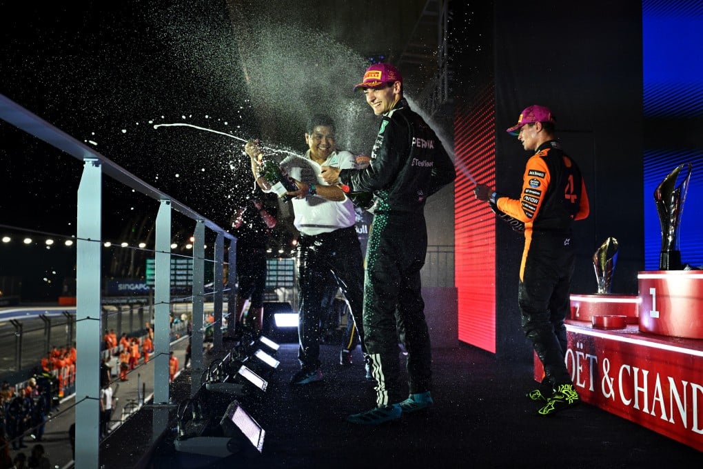 Race winner George Russell (centre) of Mercedes-AMG Petronas Formula One Team, Petronas CEO Tengku Muhammad Taufik Tengku Aziz (left) and third-placed Lando Norris of McLaren celebrate on the podium with champagne during the Singapore Grand Prix on Sunday. Photo: Formula 1 via Getty Images