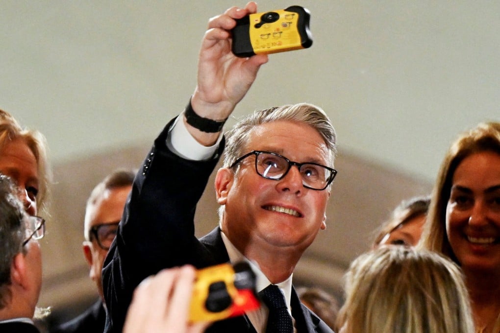 British Prime Minister Keir Starmer takes a selfie with a disposable camera while meeting business leaders at the Taj Mahal Palace in Mumbai on Wednesday. Photo: Reuters