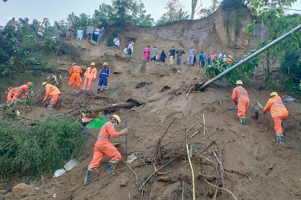 Rescue personnel look for survivors amid debris after a massive landslide hit a passenger bus on Tuesday night. Photo: National Disaster Response Force/AP