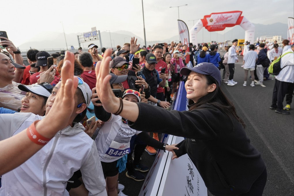 Olympic gold medalist in fencing Vivian Kong Man-wai (right) interacts with runners after finishing the Honorary Cup event of the Hong Kong-Zhuhai-Macau Bridge Half Marathon on January 5. Photo: Eugene Lee