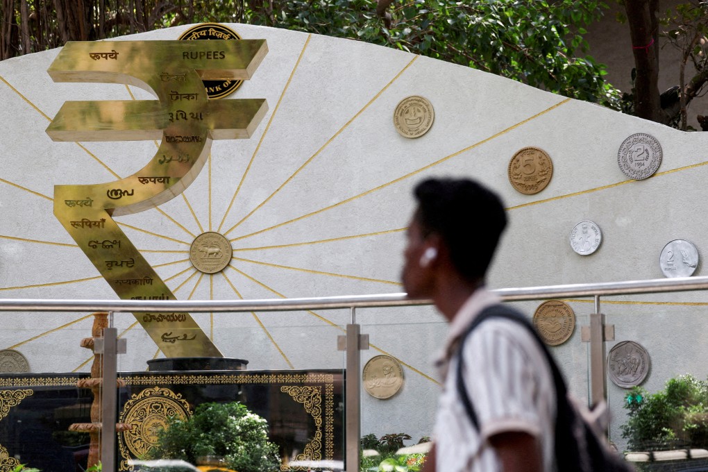 A person walks past an installation of the rupee logo and Indian currency coins outside the Reserve Bank of India’s headquarters in Mumbai on April 9. Photo: Reuters