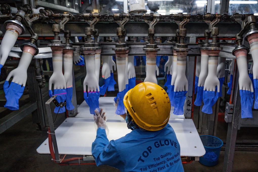 A worker inspects disposable gloves at the Top Glove factory production line on the outskirts of Kuala Lumpur. Photo: AFP