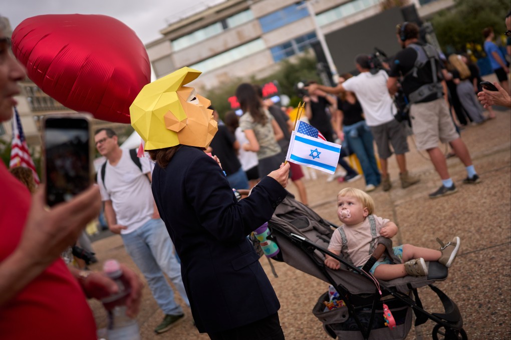 A child watches a person wearing a mask depicting US President Donald Trump as relatives and supporters of Israeli hostages celebrate in Tel Aviv after the announcement of a deal. Photo: AP