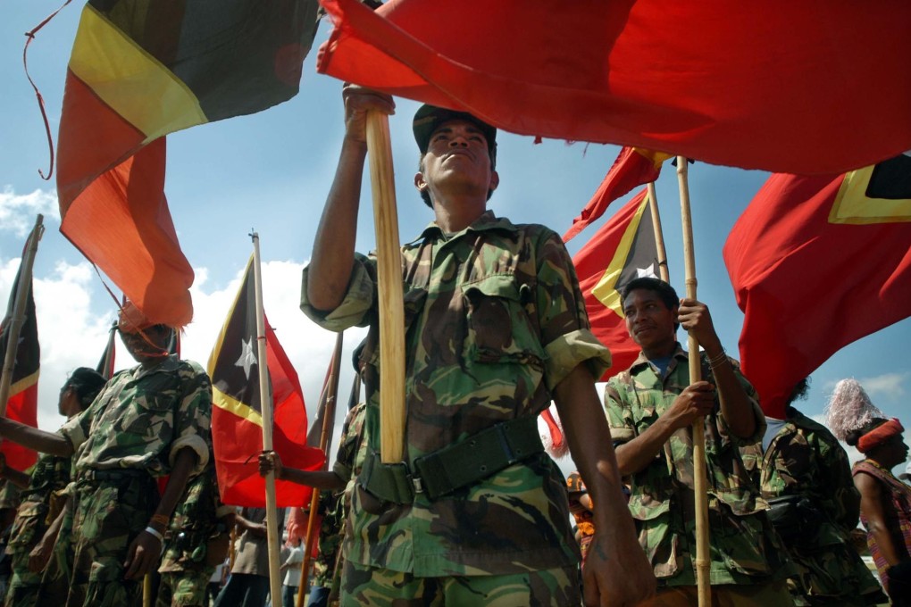 Former guerrilla forces hold Timorese flags during a ceremony in 2002 marking East Timor’s independence. Photo: AP