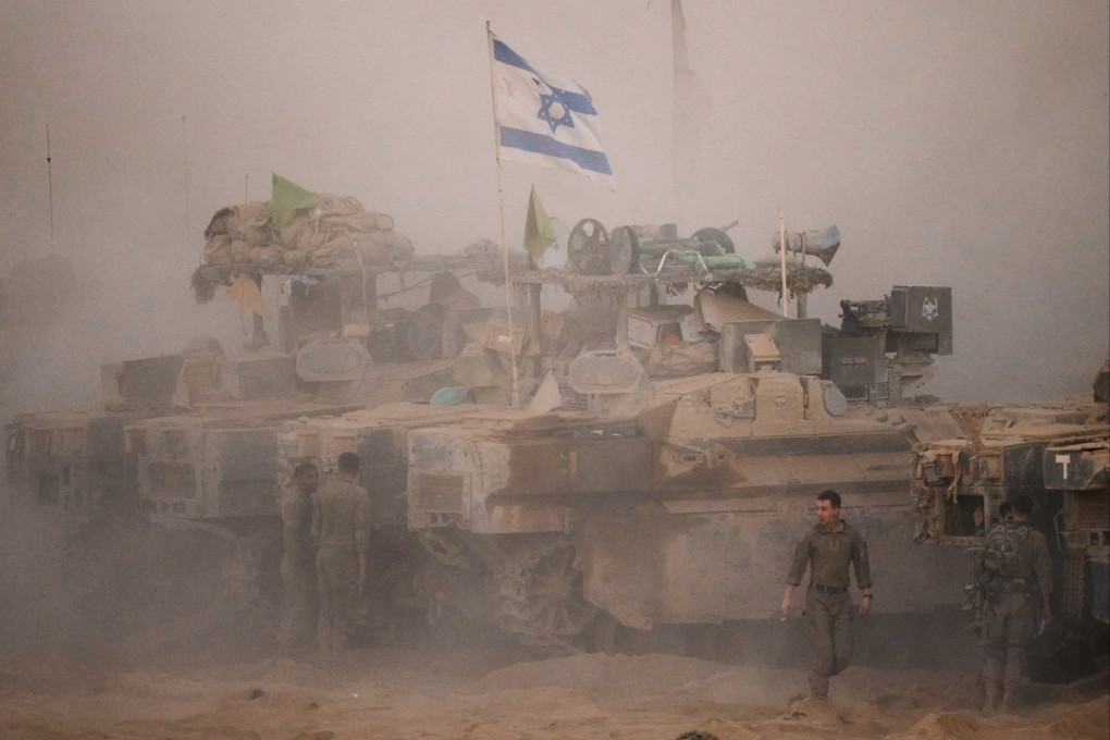 Israeli soldiers stand near their tanks along the Israeli-Gaza border, as seen from southern Israel on Friday, after Israel and Hamas agreed to a pause in their war and the release of the remaining hostages. Photo: AP