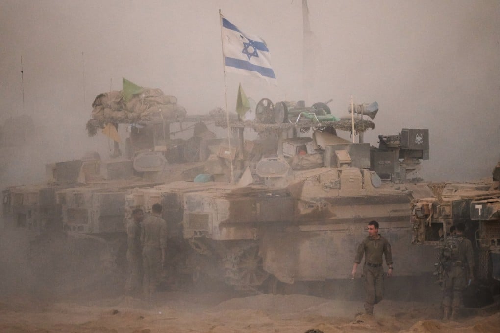 Israeli soldiers stand near their tanks along the Israeli-Gaza border, as seen from southern Israel on Friday, after Israel and Hamas agreed to a pause in their war and the release of the remaining hostages. Photo: AP