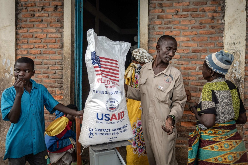 A Burundian government official speaks to newly arrived Congolese refugees while weighing a sack of rice from the final batches delivered by the now-dismantled US Agency for International Development (USAID), at the Cishemere Transit Centre near Buganda, on May 6. Photo: AFP